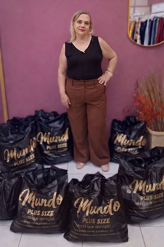 Lojista do Mundo Plus Size com as sacolas do bazar