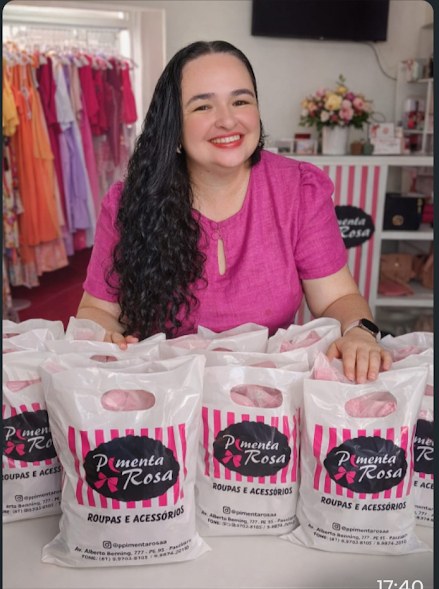 Lojista da Pimenta Rosa com as sacolas do bazar